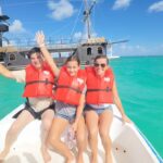 Family enjoying taxiboat tour in Punta Cana with pirate ship and turquoise waters