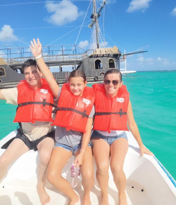 Family enjoying taxiboat tour in Punta Cana with pirate ship and turquoise waters